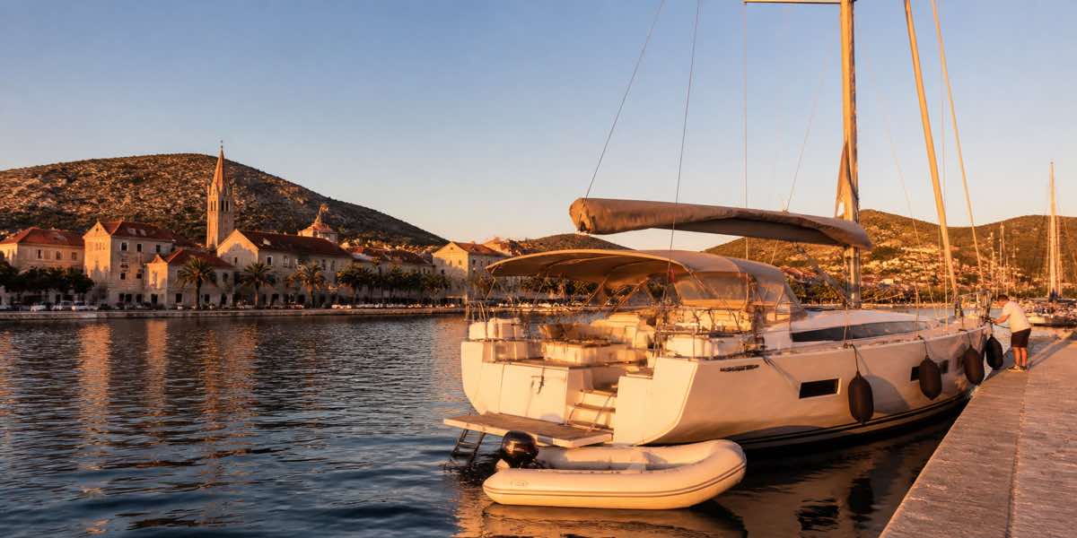 Sailing yacht anchored in clear Greek water beside a small island